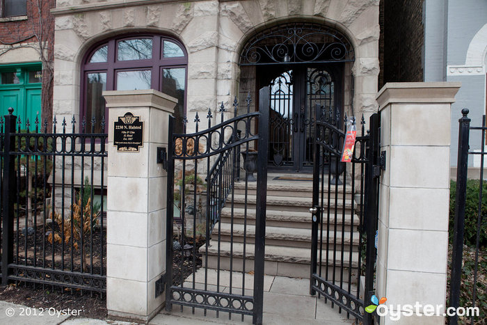 A wrought-iron and stone entrance greets guests on this quiet, residential street.