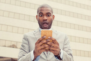 (Photo: Man Reading News on Cellphone via Shutterstock)