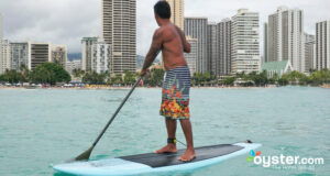A surfer balances atop his board at Waikiki Beach, Oahu