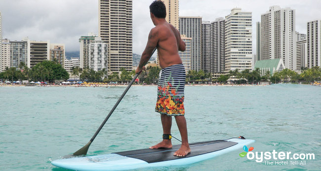 A surfer balances atop his board at Waikiki Beach, Oahu